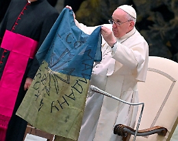Il Papa, con i bambini ucraini, mostra bandiera da Bucha